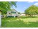 Backyard featuring a well-maintained lawn, mature trees, and a charming home exterior at 307 W Austin St, Mebane, NC 27302