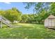Spacious backyard featuring mature trees, a storage shed, and a well-maintained lawn at 307 W Austin St, Mebane, NC 27302