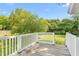 A backyard deck with white railing overlooking a large grassy area and lush trees at 307 W Austin St, Mebane, NC 27302