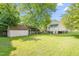 Spacious backyard with mature trees, lawn, outbuilding and house with back porch at 307 W Austin St, Mebane, NC 27302