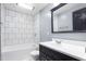 Well-lit bathroom with white tiled shower, black framed mirror, and a vanity at 307 W Austin St, Mebane, NC 27302