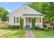 Charming bungalow with a green metal roof, a small porch, and manicured greenery in the front yard at 307 W Austin St, Mebane, NC 27302