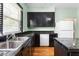 This kitchen has tiled countertops and black cabinets, along with a double sink at 307 W Austin St, Mebane, NC 27302