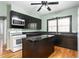 Galley kitchen with black cabinetry, light-green walls, an island, and a white gas range at 307 W Austin St, Mebane, NC 27302
