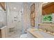 Updated bathroom features a glass-enclosed shower, floral wallpaper, a granite vanity, and natural light at 3308 Cobblestone Court Ct, Raleigh, NC 27607