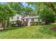 Charming two-story home with a lush green lawn, mature trees, and well-manicured shrubs at 3308 Cobblestone Court Ct, Raleigh, NC 27607