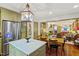 Olive-green kitchen with stainless steel refrigerator, marble-top island, hardwood floors, and a view into the living room at 3308 Cobblestone Court Ct, Raleigh, NC 27607