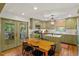 Well-lit kitchen features a wooden dining table, olive-green cabinets, stainless steel appliances, and hardwood floors at 3308 Cobblestone Court Ct, Raleigh, NC 27607