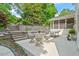 Outdoor patio with stone retaining wall, tiered landscaping, and casual seating area, ideal for entertaining at 3308 Cobblestone Court Ct, Raleigh, NC 27607