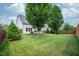 Expansive backyard with green grass, mature trees, and a deck perfect for outdoor activities at 337 Botan Way, Hillsborough, NC 27278