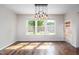 Bright dining room with hardwood floors, modern lighting, and backyard views at 337 Botan Way, Hillsborough, NC 27278