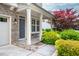 Inviting covered front porch with a cozy bench and beautifully landscaped surroundings at 337 Botan Way, Hillsborough, NC 27278