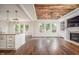 Open-concept living area with a fireplace, wood ceiling detail, and ample natural light at 337 Botan Way, Hillsborough, NC 27278