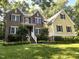 Charming two-story home featuring brick and yellow siding with black shutters, surrounded by lush greenery at 3650 Pleasants Ridge Dr, Wake Forest, NC 27587