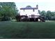 A well-maintained backyard features a large lawn and a wooden deck with steps leading down to the yard at 3832 Doeskin Dr, Apex, NC 27539