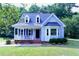 Charming front exterior with a cozy porch, blue shutters, and well-manicured lawn at 3832 Doeskin Dr, Apex, NC 27539