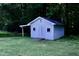 A charming outbuilding featuring a blue painted exterior and double doors sits in the backyard at 3832 Doeskin Dr, Apex, NC 27539
