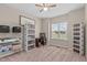 Bright bedroom with a ceiling fan, natural light, storage shelves, and an office desk at 402 S Wilma St, Angier, NC 27501