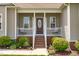 Inviting front porch with white railing, brick stairs, and a stylish front door, offering curb appeal at 402 S Wilma St, Angier, NC 27501