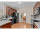 Well-equipped kitchen with dark cabinets, granite countertops, and modern appliances, offering a view to dining area at 402 S Wilma St, Angier, NC 27501