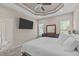 Bright main bedroom featuring a trey ceiling, large TV, windows, and attached bathroom at 402 S Wilma St, Angier, NC 27501