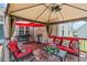 Inviting covered patio with red cushions, grill, and ample seating for outdoor enjoyment at 402 S Wilma St, Angier, NC 27501