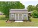 Charming shed featuring a weathered metal roof, double doors, and decorative landscaping at 402 S Wilma St, Angier, NC 27501