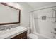 Modern bathroom featuring a white subway tile shower and a wood-trimmed mirror and vanity at 4021 Converse Dr, Raleigh, NC 27609
