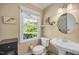 Bathroom featuring pedestal sink, toilet, and large window for natural light at 4021 Converse Dr, Raleigh, NC 27609