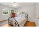 Well-lit bedroom featuring a wrought iron bed frame, hardwood floors, and two windows at 4021 Converse Dr, Raleigh, NC 27609