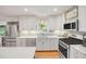 Updated kitchen with white cabinetry, stainless steel appliances, and sleek countertops at 4021 Converse Dr, Raleigh, NC 27609