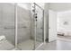 Glass shower enclosure with gray tile and built-in shelves in spacious bathroom at 427 Bluffberry Way, Hillsborough, NC 27278