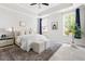Bright bedroom featuring tray ceilings, two windows, and a cozy sitting area at 427 Bluffberry Way, Hillsborough, NC 27278