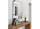 Console table with decorative books and candles reflected in bedroom mirror at 427 Bluffberry Way, Hillsborough, NC 27278