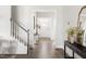 Bright entryway featuring hardwood floors, a staircase with white railing, and a view of the front door at 427 Bluffberry Way, Hillsborough, NC 27278