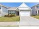 Attractive exterior featuring a two-car garage, landscaped front yard, and a mix of brick and siding elements at 427 Bluffberry Way, Hillsborough, NC 27278