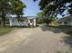 Side view of a single-story home featuring a graveled yard and mature trees providing shade at 429 5Th & Brogden Rd, Smithfield, NC 27577