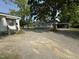 Gravel yard leading to house with an adjacent carport; mature trees provide ample shade at 429 5Th & Brogden Rd, Smithfield, NC 27577