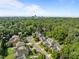 Overhead view of a residential community surrounded by mature trees and a distant skyline at 4913 Great Meadows Ct, Raleigh, NC 27609