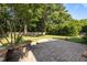 Lush backyard with a stone patio surrounded by mature trees and landscaping at 4913 Great Meadows Ct, Raleigh, NC 27609