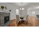 Open dining room with hardwood floors, stone fireplace, stylish lighting and doorway access to other living spaces at 4913 Great Meadows Ct, Raleigh, NC 27609