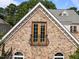 Detailed exterior view displaying stone accents, a dormer window, and a Juliette balcony at 4913 Great Meadows Ct, Raleigh, NC 27609