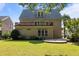 Back exterior showing large lawn with stone patio and covered balcony at 4913 Great Meadows Ct, Raleigh, NC 27609
