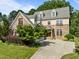 Beautiful stone home featuring dormer windows and a spacious driveway surrounded by lush landscaping at 4913 Great Meadows Ct, Raleigh, NC 27609