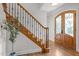 Elegant foyer with a staircase featuring decorative iron spindles and a decorative front door with glass inserts at 4913 Great Meadows Ct, Raleigh, NC 27609