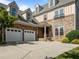 Elegant exterior featuring stone accents, an attached two-car garage, arched window and meticulously maintained landscaping at 4913 Great Meadows Ct, Raleigh, NC 27609