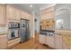 Gourmet kitchen boasts stainless steel appliances, custom cabinets, and a stone backsplash at 4913 Great Meadows Ct, Raleigh, NC 27609