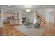 Open concept living space with kitchen view, fireplace, staircase, hardwood floors and natural lighting at 4913 Great Meadows Ct, Raleigh, NC 27609