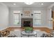 Cozy living room featuring a stone fireplace, crown molding, and natural light from the many windows at 4913 Great Meadows Ct, Raleigh, NC 27609