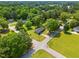 Aerial view showcases the home and neighborhood with mature trees, a garden area, and a new roof at 492 N Dunn St, Angier, NC 27501